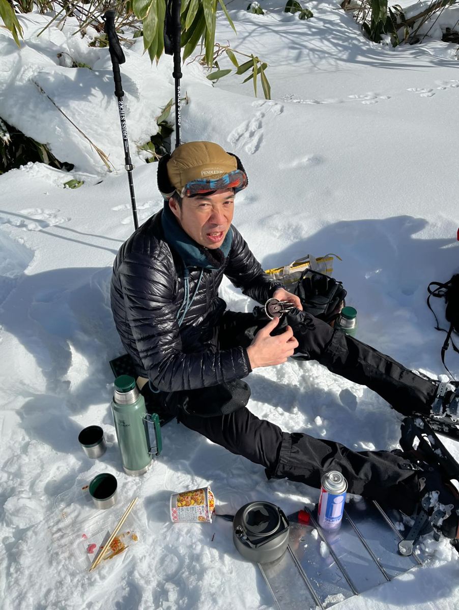 雪の上で昼食を準備する藤田 央